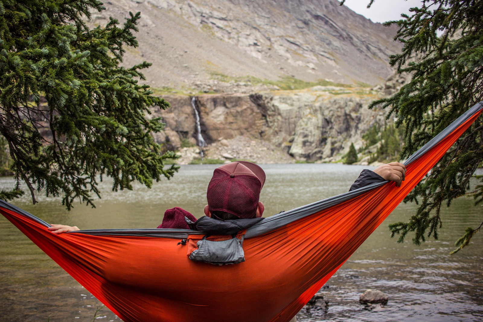 A man relaxing in a hammock strung between trees