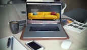 turned on MacBook Pro beside gray mug