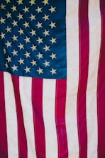 A close-up of a U.S. flag alongside a business meeting in progress.
