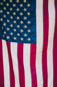 A close-up of a U.S. flag alongside a business meeting in progress.