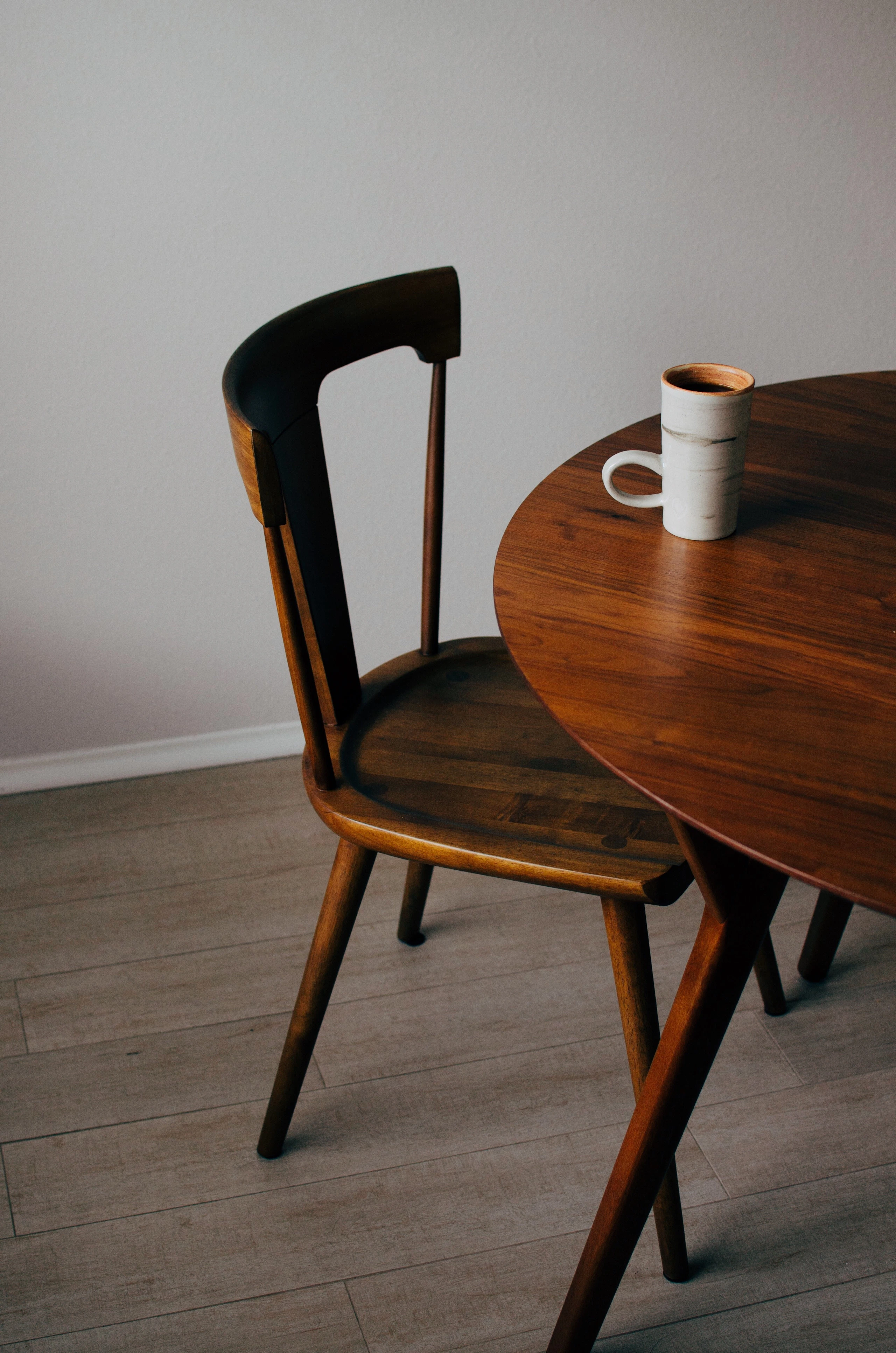 Dark wooden chair beside a round walnut table