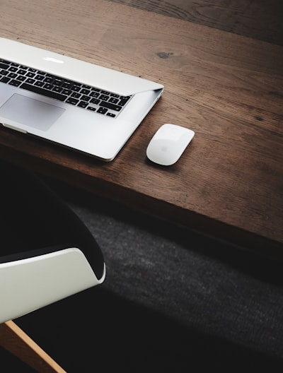 Apple MacBook beside computer mouse on table