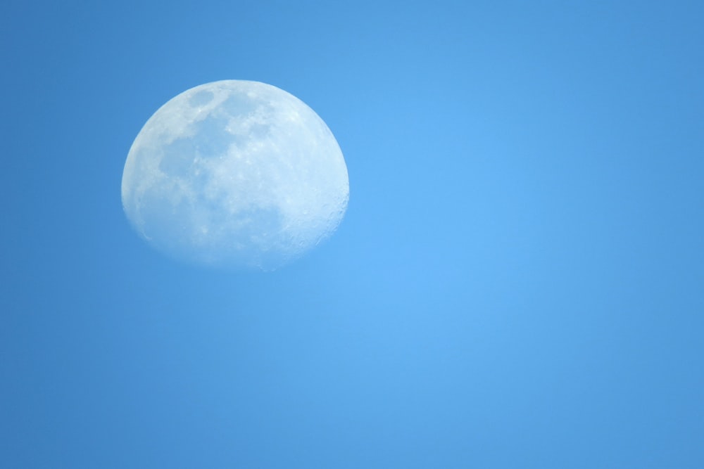 a clear blue sky with a half moon