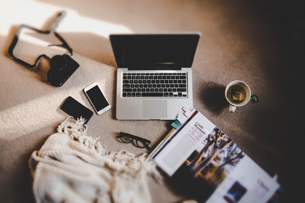 white ceramic mug near MacBook Pro