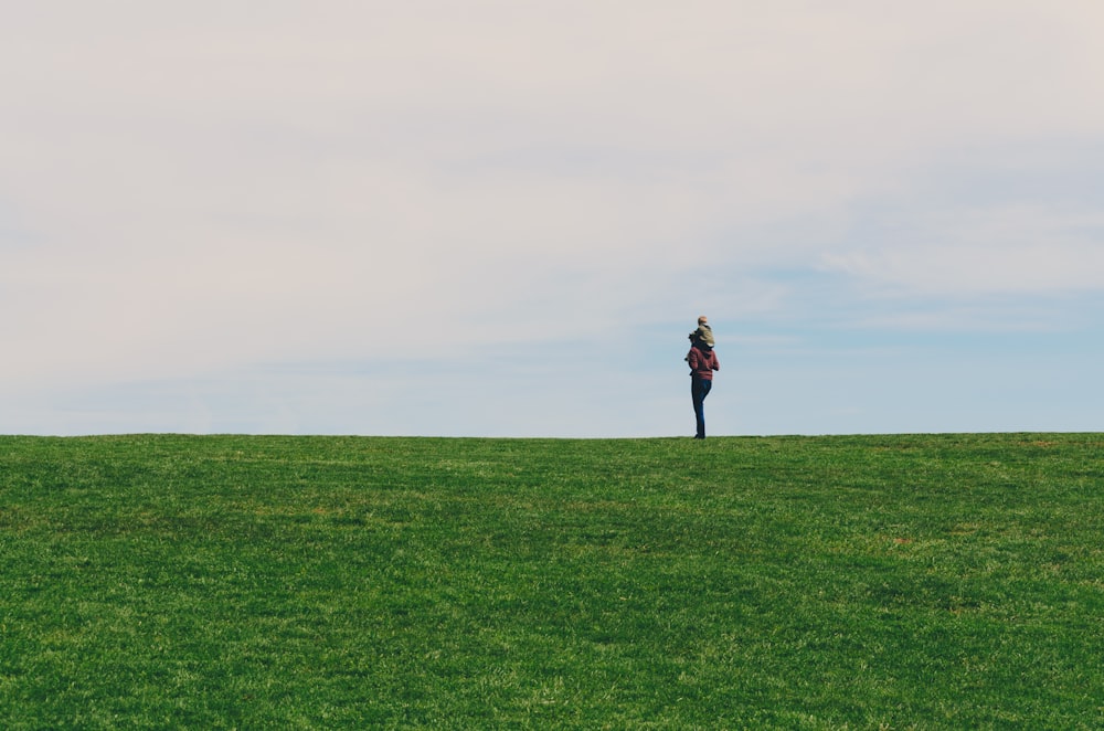person standing on green grass field