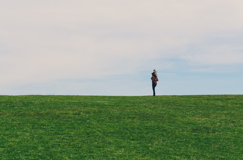 personne debout sur un champ d’herbe verte