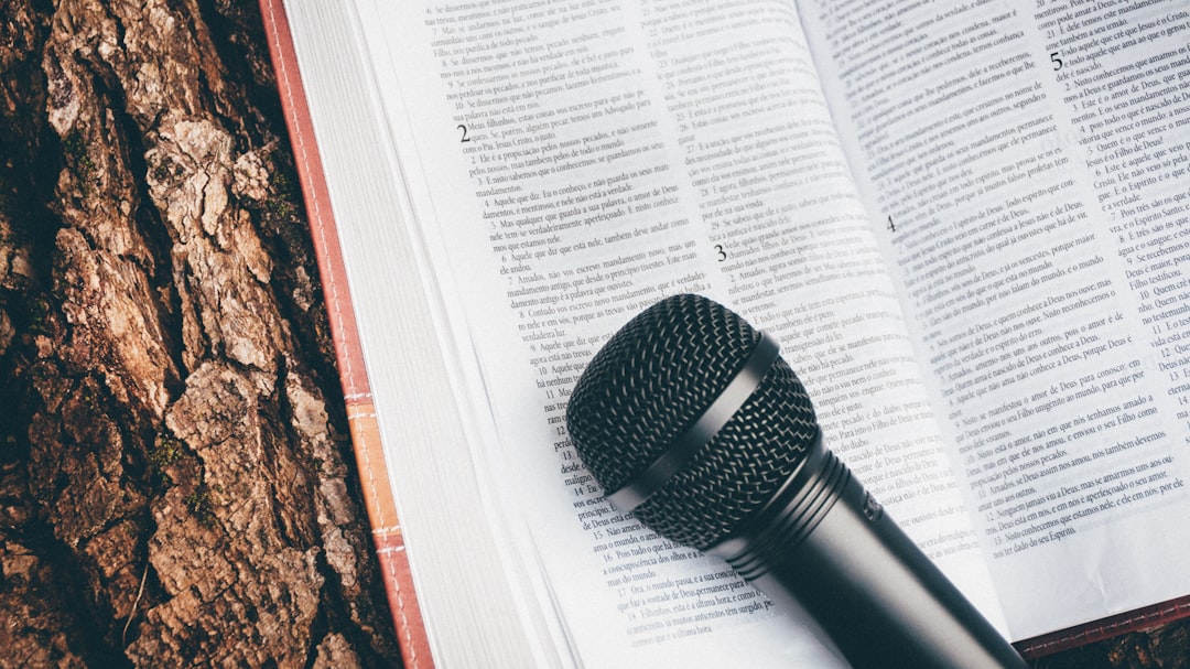 A microphone and bible resting on a tree stump