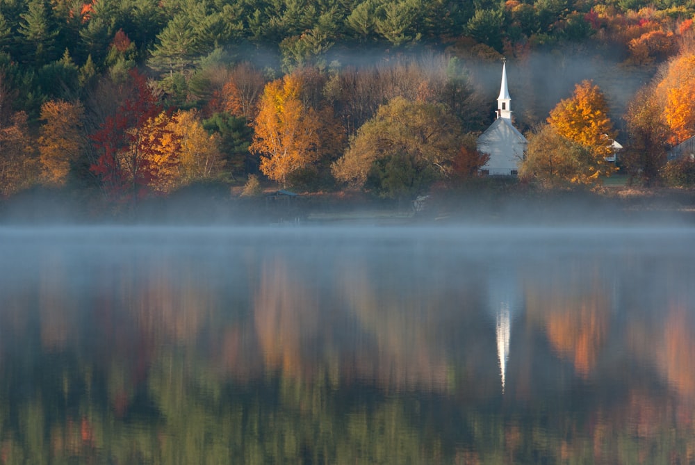 white chapel beside body of water