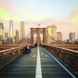The Brooklyn Bridge glowing at sunset, as seen from a moving tour boat on the East River.