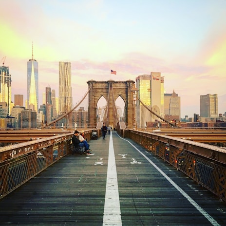 The Brooklyn Bridge glowing at sunset, as seen from a moving tour boat on the East River.