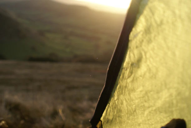 Close-up of a sturdy Campora tent fabric with morning dew glistening on it.