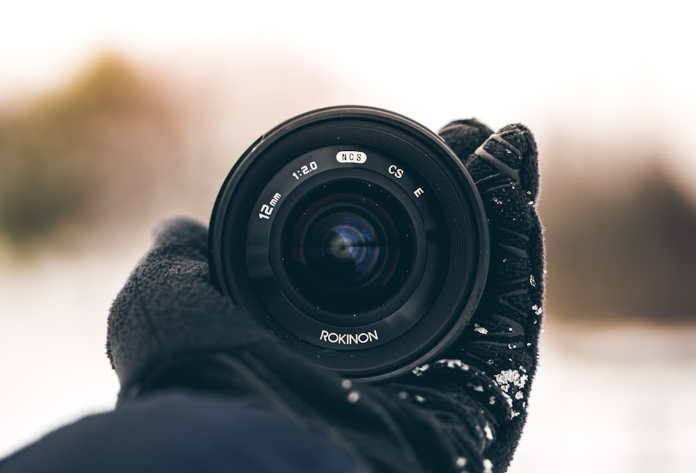 person holding Rokinon zoom lens