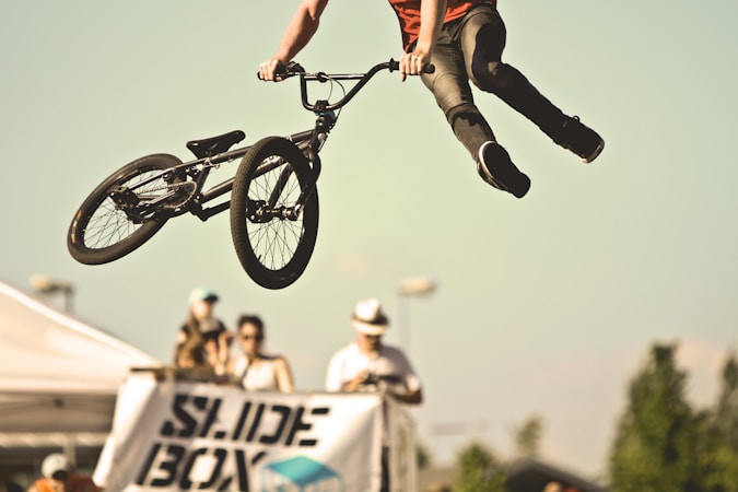 A BMX rider launching off a ramp during a freestyle stunt show, similar to the assemblies held at Las Vegas high schools