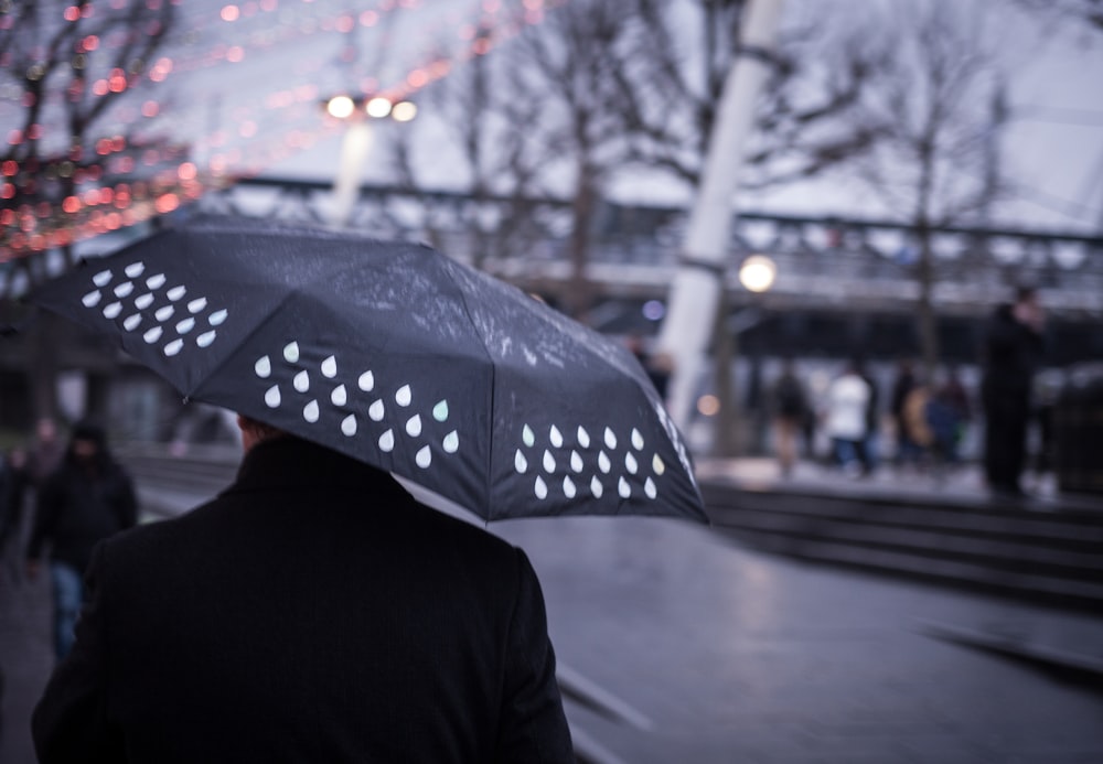 person holding black umbrella