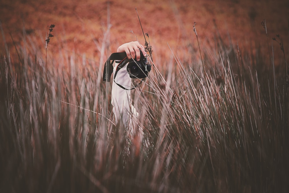 person holding Canon DSLR camera