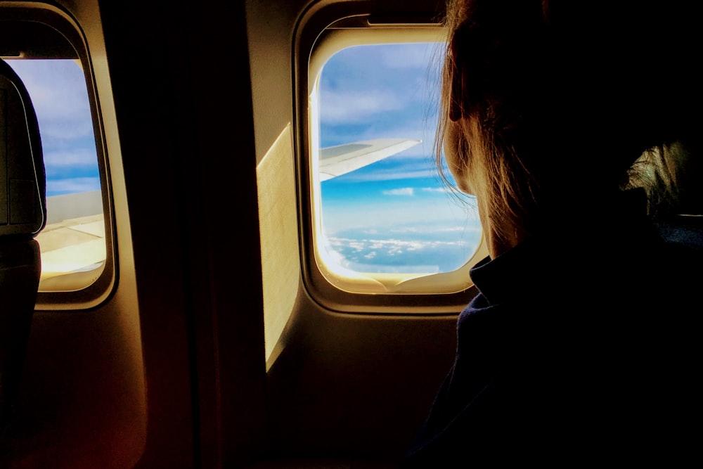 Person, die aus dem Flugzeugfenster schaut