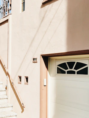 Before and after shot of a stucco repair on a residential building facade.