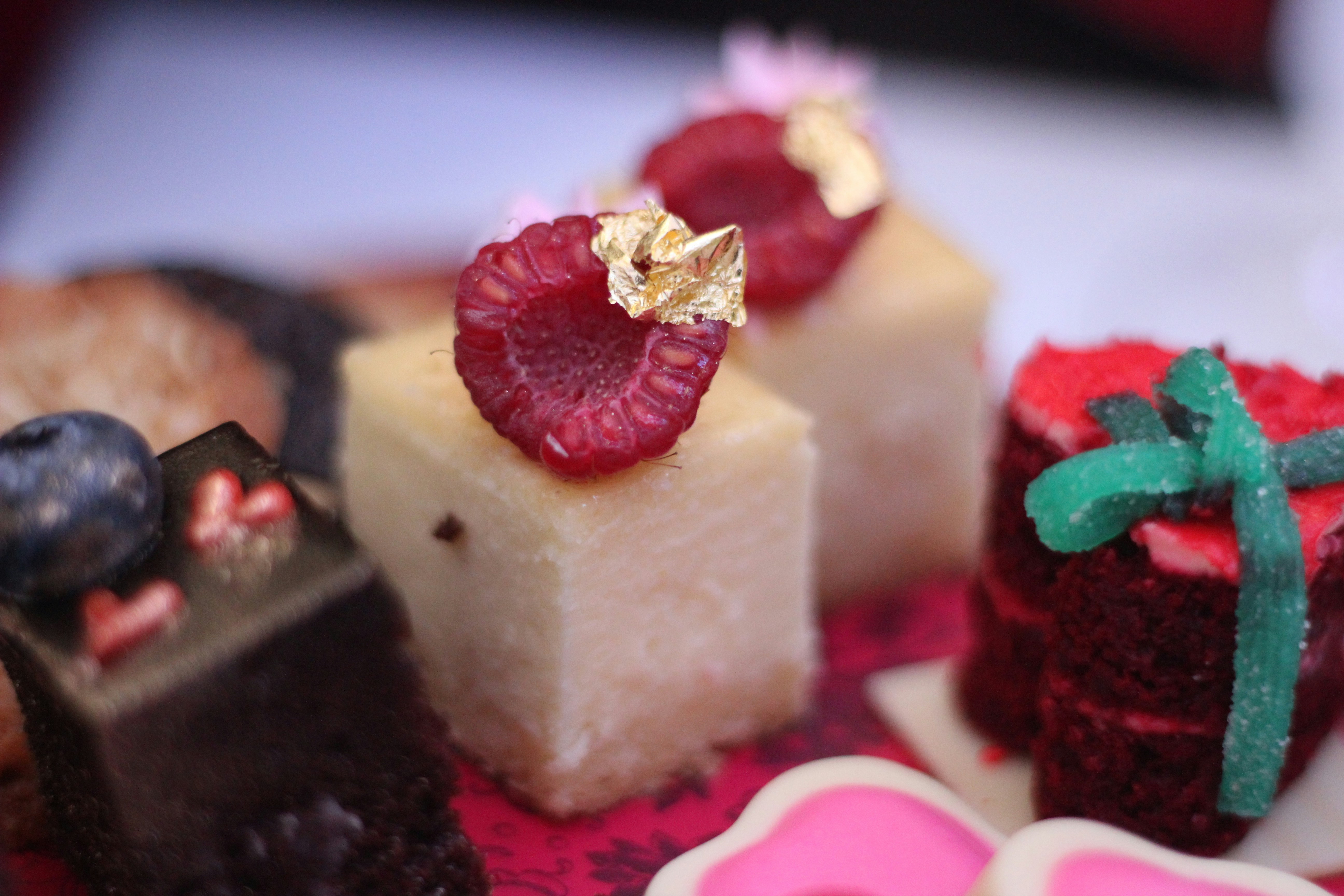 Beautifully arranged dessert course with gold leaf and berry compote