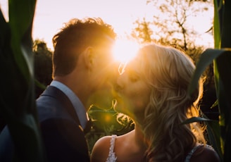 woman and man kissing on grass field