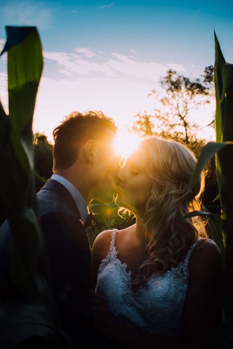 femme et homme s’embrassant sur un terrain en herbe