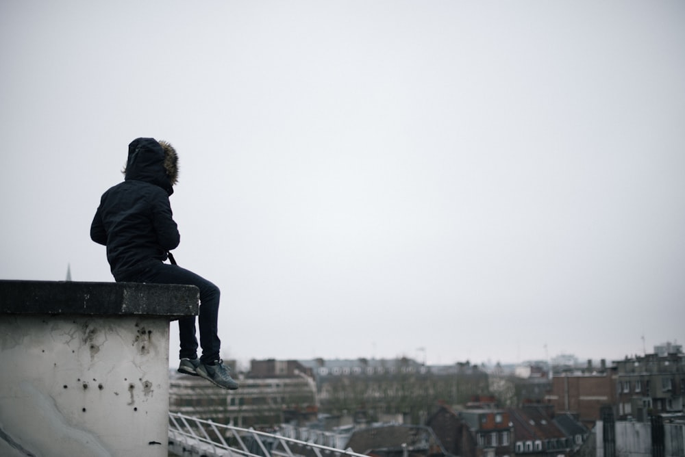 person sitting on roof top during daytime