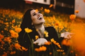 woman laughing on flower field