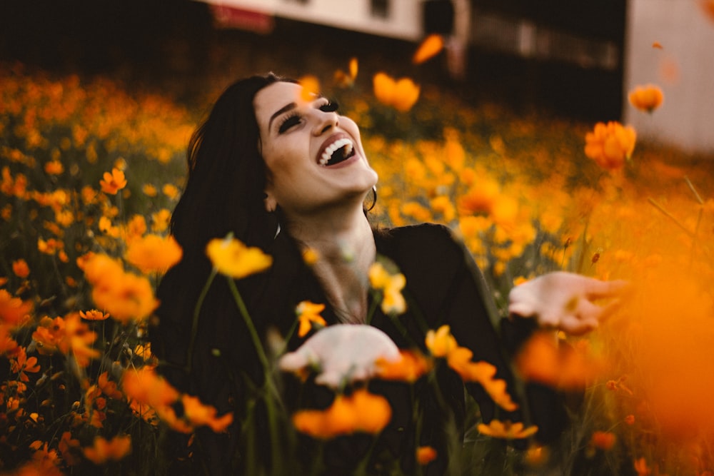 woman laughing on flower field