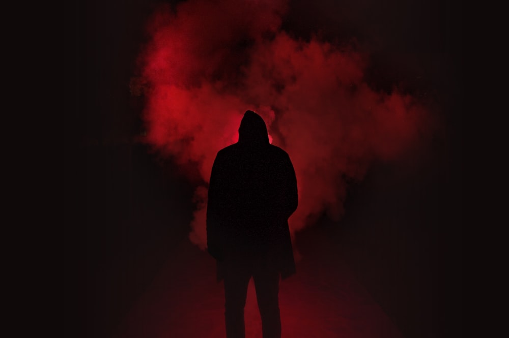 silhouette de personne sur un endroit sombre avec de la fumée