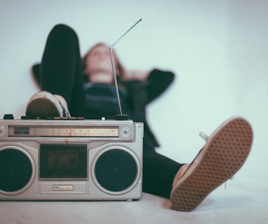 woman laying on bed near gray radio