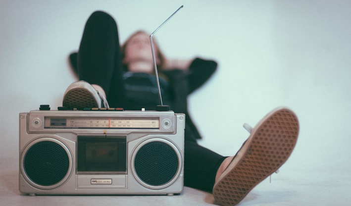 woman laying on bed near gray radio