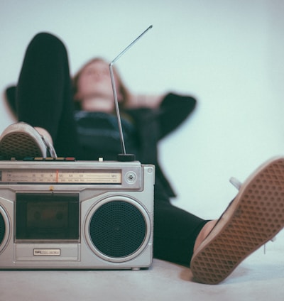 woman laying on bed near gray radio