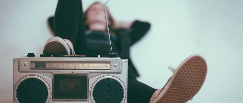 woman laying on bed near gray radio