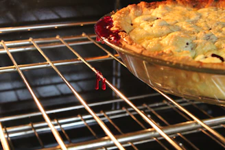 A warm, glowing shot of a freshly baked pie cooling on a kitchen counter with steam rising gently.