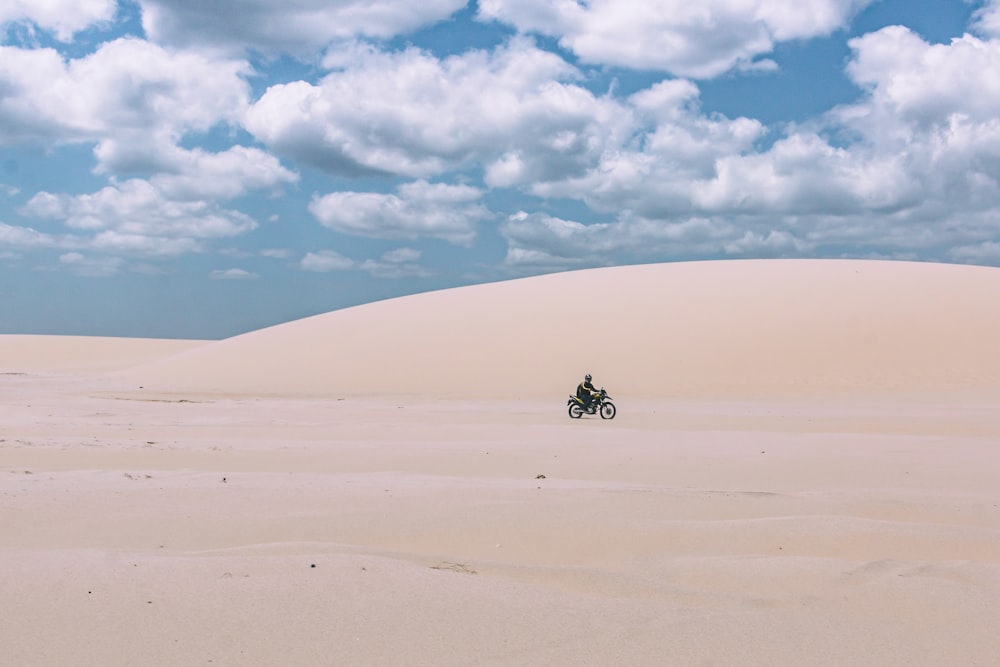 person rides on motorcycle under white sky