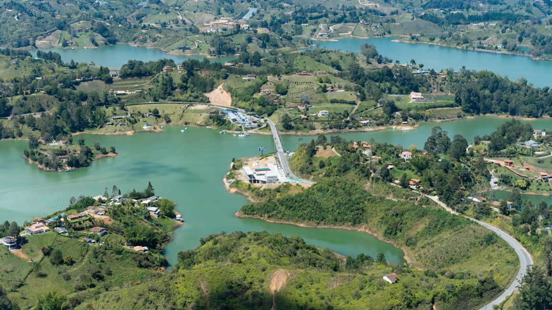 aerial photography of curved road heading towards bridge near body of water,