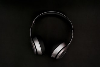 A modern pair of wireless headphones on a sleek black background.