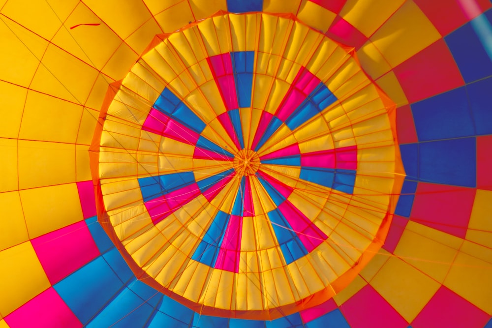 Low-Angle-Fotografie eines gelben, rosa und schwarzen Heißluftballons