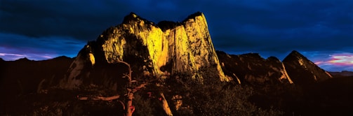 A dramatic landscape shot of a mountain range under golden hour light.