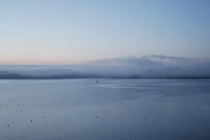 Early morning view of the calm lagoon near Bourail with soft pastel skies.