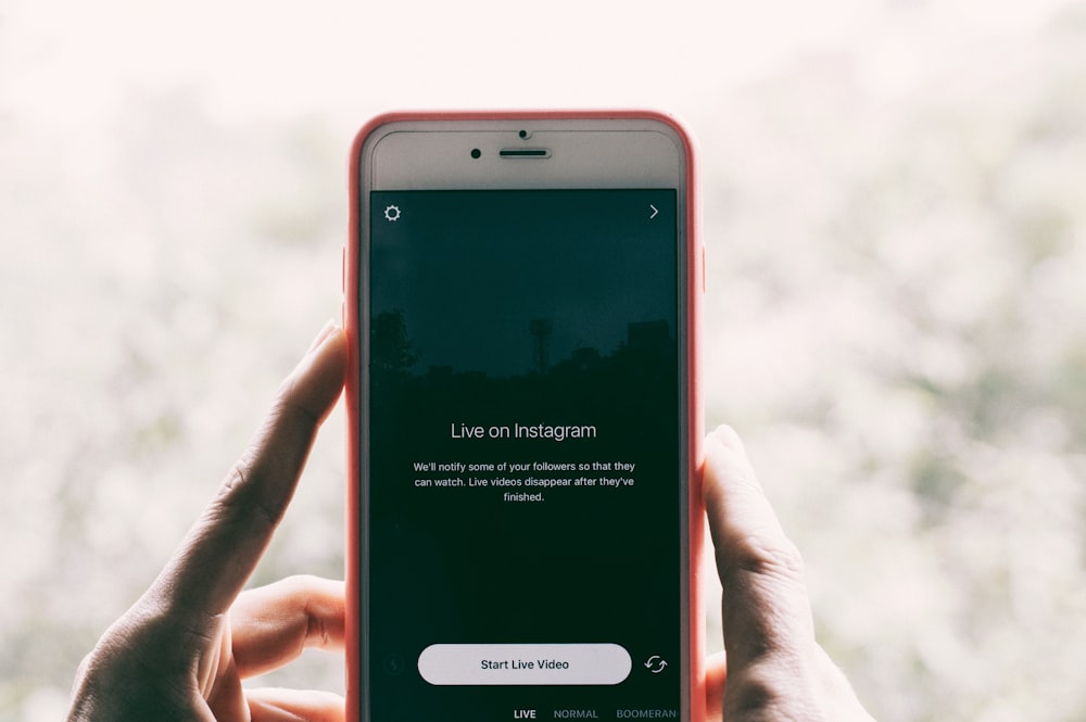 A person holding an iPhone with Instagram live videos open