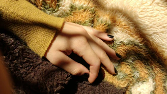 A set of freshly painted nails in bright colors, resting on a cozy blanket.
