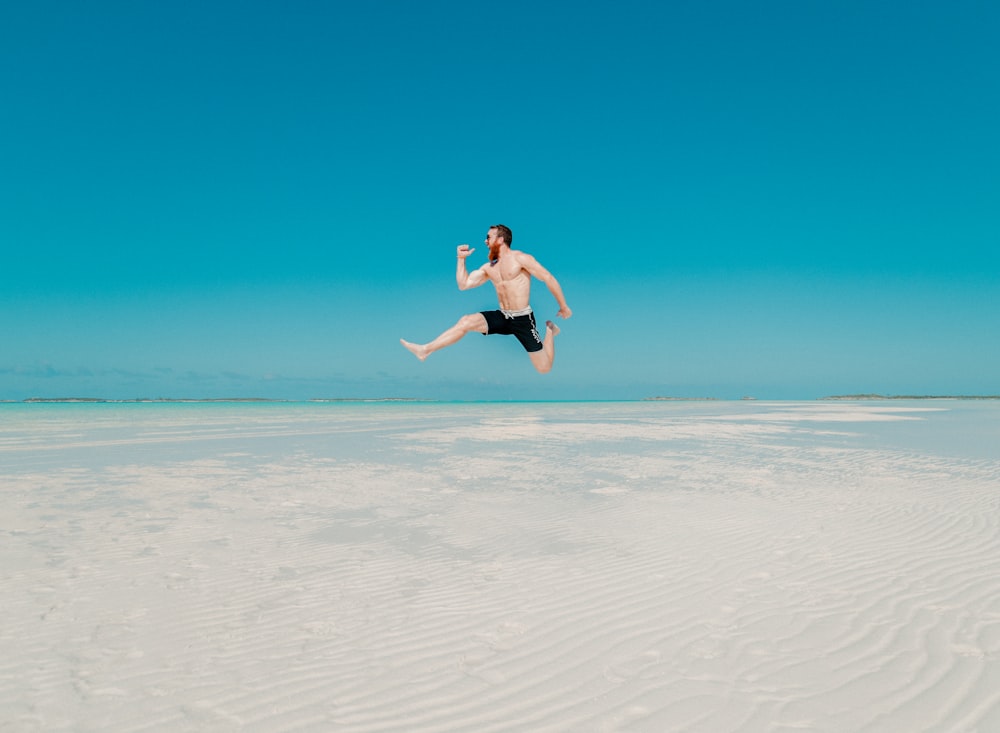 time lapse photography of man jumping at seashore