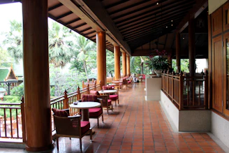 An elegant outdoor dining area with patterned tile flooring and tasteful plant accents.