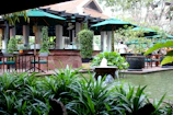 Tranquil outdoor patio surrounded by lush greenery and soft lighting.