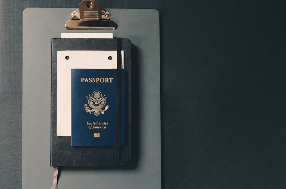 A passport resting on a clipboard representing the documents assembled for a UAE Golden Visa application.