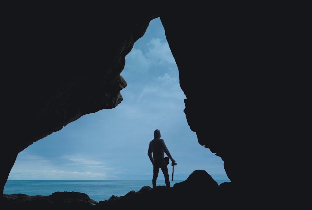 silhouette of person standing on rock