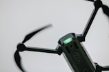 A close-up view of a drone with spinning rotors, capturing its metallic structure and a green indicator light on its body.