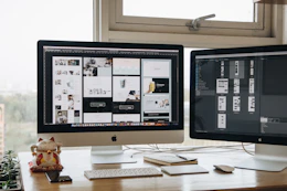 Two monitors setup next to each other on a computer desk
