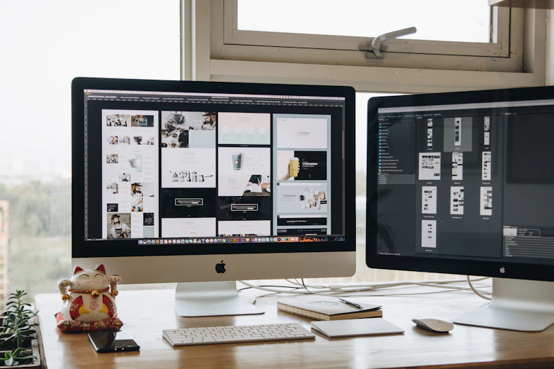 Two monitors setup next to each other on a computer desk