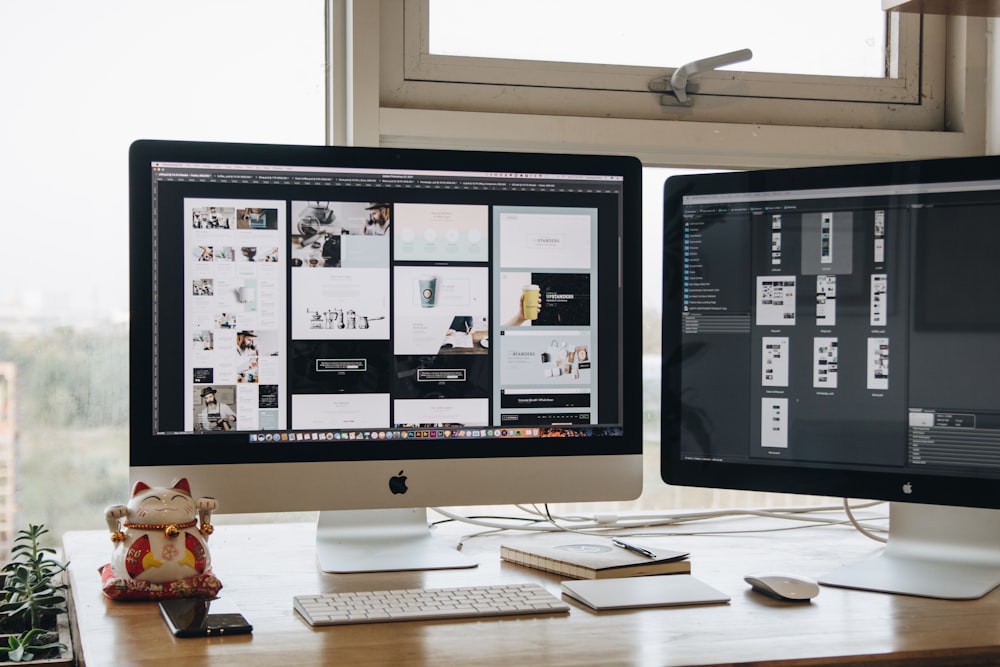 Two monitors setup next to each other on a computer desk.